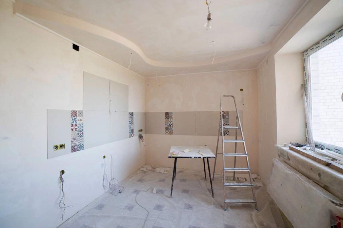 Pièce en cours de rénovation intérieure, murs préparés et sol protégé